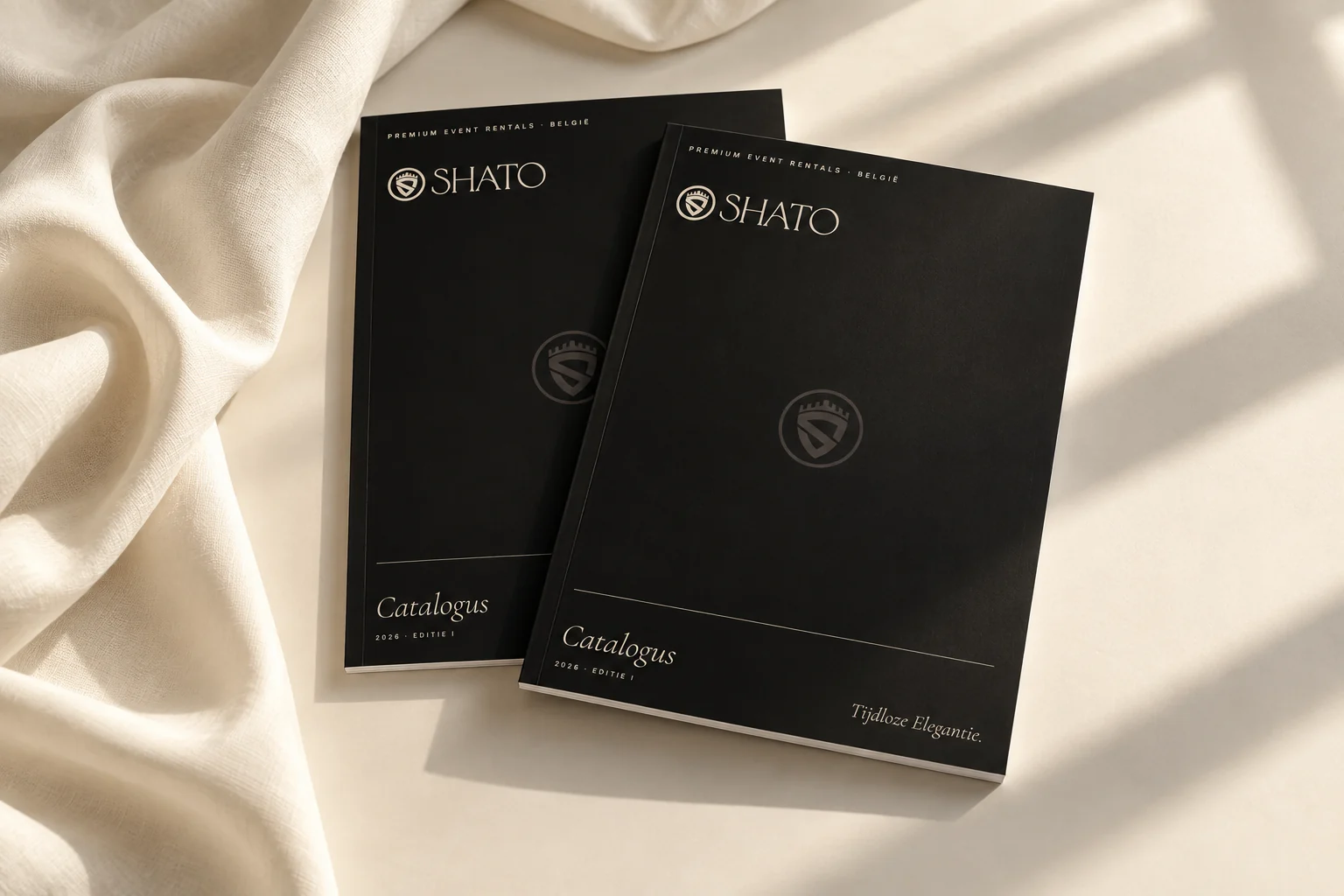 Shato-catalogi in zwart en zandkleur op een tafel met ivoorkleurige stof